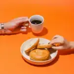 person holding white ceramic mug with brown liquid